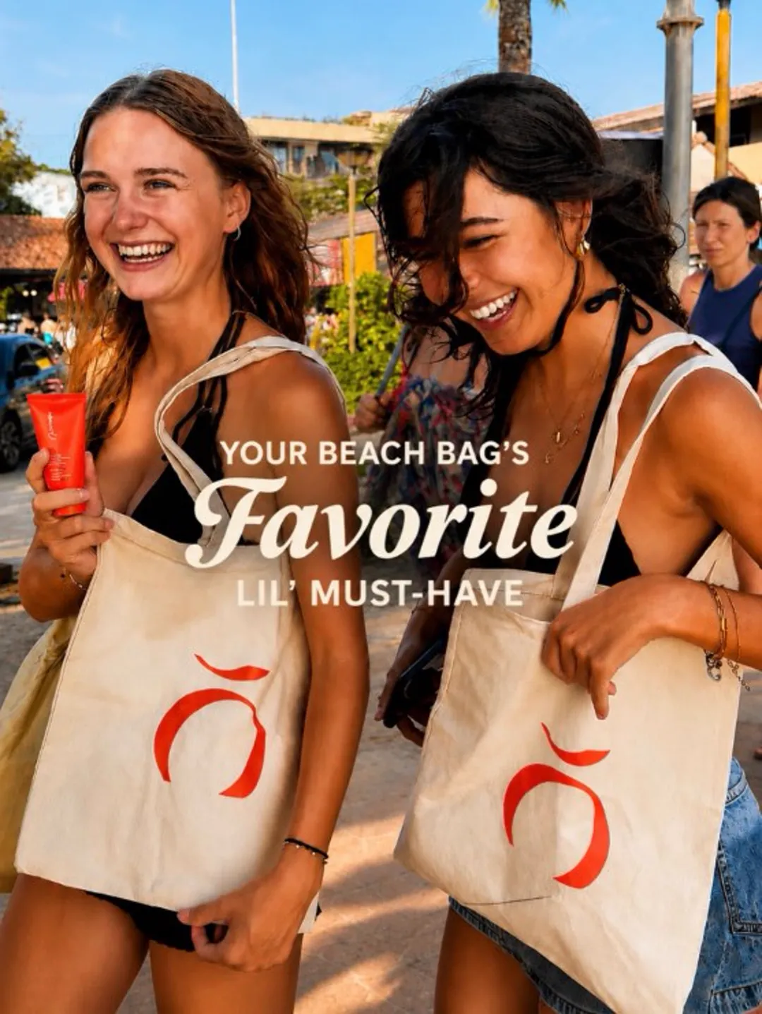 Your beach bag's favorite lil' must-have — two friends smiling with Orange tote bags.